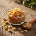 Babool Gum (Gond Babool/Acacia Arabica Gum) golden amber resin pieces on wooden surface with glass bowl and wooden spoon