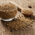 Celery Seeds (Tukhm-e-Karafs/Apium Graveolens) tiny pale brown aromatic seeds on wooden surface with glass bowl and wooden spoon