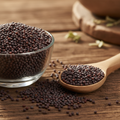 Brown Mustard seeds (Rai/Khardal/Brassica Juncea) small dark reddish-brown seeds on wooden surface with glass bowl and wooden spoon