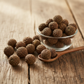 Australian Pine Tree Fruit (Casuarina cone fruits) on wooden surface with glass bowl and wooden spoon