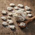 Cuttlefish Bone (Samar ul Bahar/Sepia Officinalis) dried white chalky bone pieces and powder on wooden surface with glass bowl and wooden spoon
