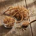 Blackeyed Susan Roots (Rudbeckia Hirta) dried tan-brown fibrous roots on wooden surface with glass bowl and wooden spoon