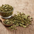 Dried Senna Leaves (Sana Makki) on wooden surface with glass bowl and wooden spoon